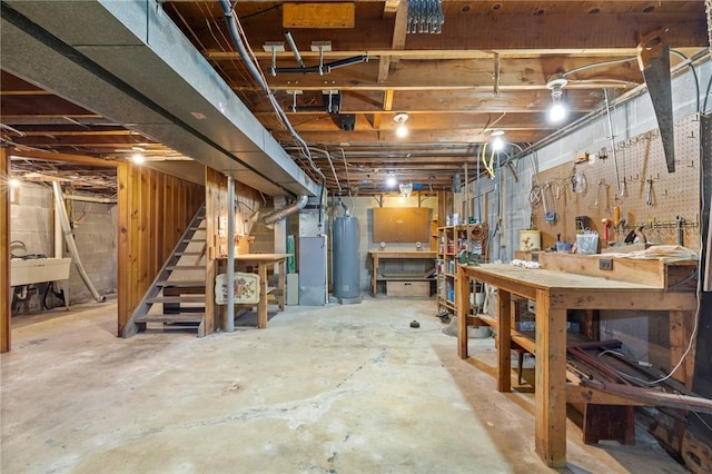 130 Quay Dr, Irondequoit, NY 14617 - unfinished below grade area with water heater, a workshop area, and stairs