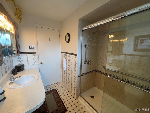 66 Fairlane Ave, Tonawanda-Town, NY 14150 - bathroom with a stall shower, vanity, a wainscoted wall, and tile patterned floors