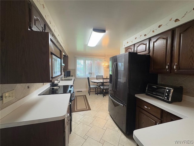 66 Fairlane Ave, Tonawanda-Town, NY 14150 - kitchen with dark brown cabinets, backsplash, light countertops, electric range oven, and freestanding refrigerator