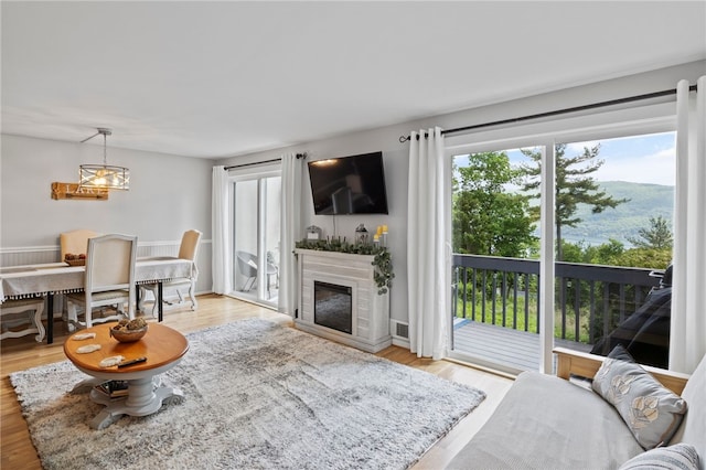 3 Harbour Ln, South Bristol, NY 14424 - living area featuring a glass covered fireplace, light wood-type flooring, and a chandelier