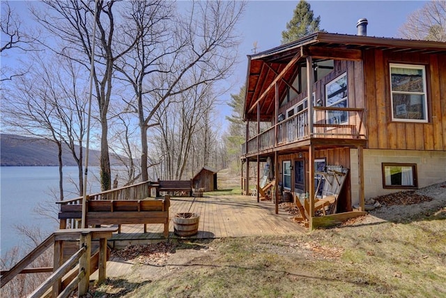 6121 Beechtree Dr, South Bristol, NY 14512 - view of side of home featuring a deck with water view, an outbuilding, and a patio