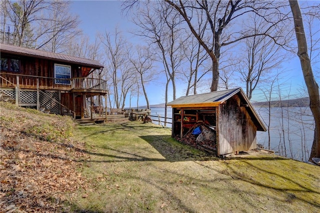 6121 Beechtree Dr, South Bristol, NY 14512 - view of green lawn featuring a deck with water view and an outbuilding