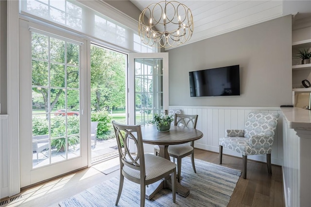 15 Cathedral Oaks, Perinton, NY 14450 - dining room with healthy amount of natural light, a chandelier, a wainscoted wall, and wood finished floors