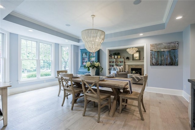 15 Cathedral Oaks, Perinton, NY 14450 - dining area featuring a fireplace, a raised ceiling, a chandelier, light wood-style flooring, and recessed lighting