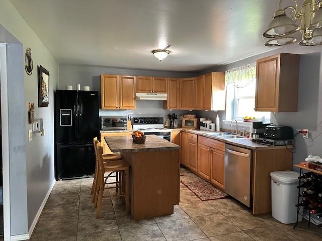 41 Wallman Dr, Henrietta, NY 14467 - kitchen with appliances with stainless steel finishes, under cabinet range hood, a center island, a chandelier, and a breakfast bar area