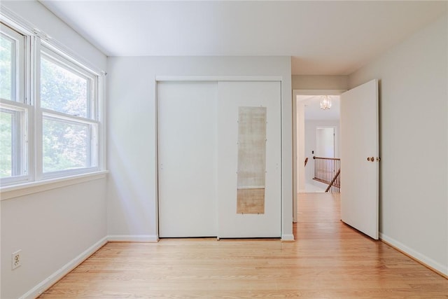 21 Chipping, Perinton, NY 14450 - unfurnished bedroom with light wood-style floors, multiple windows, and a closet