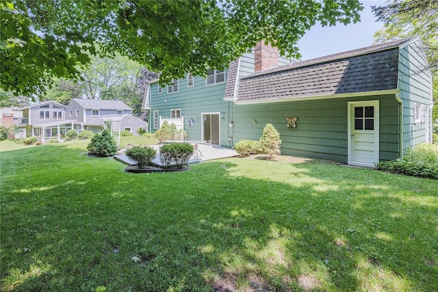 21 Chipping, Perinton, NY 14450 - back of property with a shingled roof, a patio, a chimney, and a lawn