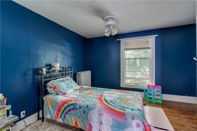 302 N James St, Wilna, NY 13619 - bedroom featuring radiator heating unit and wood finished floors