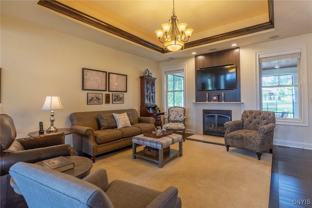 3389 Long Shadow Dr, Lysander, NY 13027 - living area featuring a raised ceiling, a chandelier, a glass covered fireplace, ornamental molding, and wood finished floors