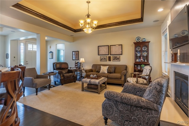 3389 Long Shadow Dr, Lysander, NY 13027 - living area featuring a chandelier, a tray ceiling, wood finished floors, crown molding, and a glass covered fireplace