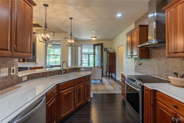 3389 Long Shadow Dr, Lysander, NY 13027 - kitchen featuring stainless steel appliances, wall chimney exhaust hood, dark wood finished floors, light countertops, and a chandelier