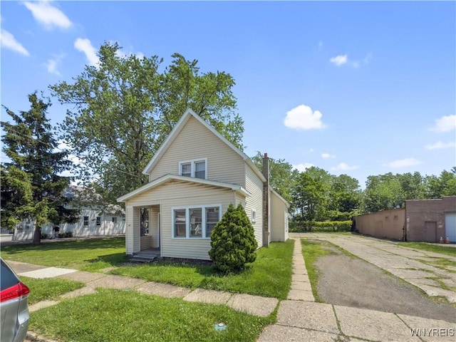 69 Halstead Ave, Cheektowaga, NY 14212 - view of front of house featuring driveway, a front lawn, and a chimney