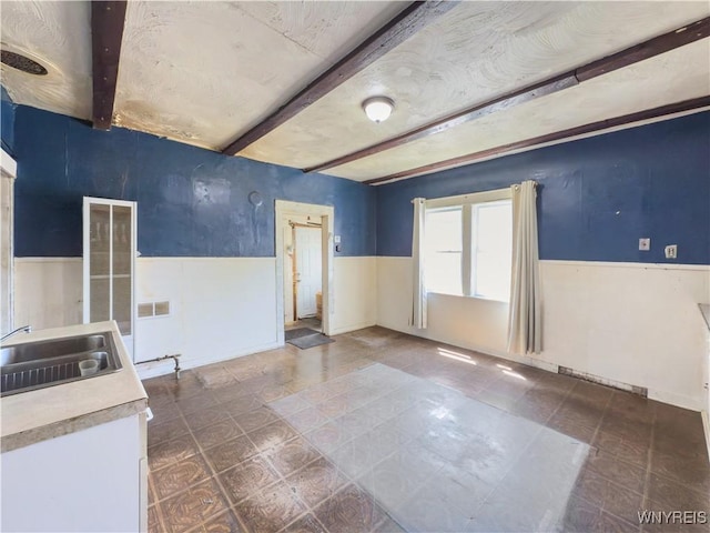 69 Halstead Ave, Cheektowaga, NY 14212 - empty room with wainscoting and beam ceiling