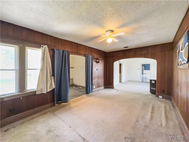 69 Halstead Ave, Cheektowaga, NY 14212 - unfurnished room with wooden walls, arched walkways, a ceiling fan, and a textured ceiling