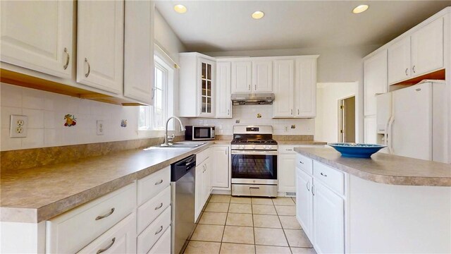 106 Woodsview, Erwin, NY 14870 - kitchen featuring appliances with stainless steel finishes, under cabinet range hood, tasteful backsplash, white cabinetry, and light tile patterned floors