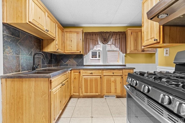 500 Glenwood Ave, Syracuse, NY 13207 - kitchen featuring stainless steel gas range, extractor fan, dark countertops, tasteful backsplash, and light tile patterned floors