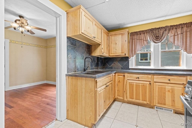 500 Glenwood Ave, Syracuse, NY 13207 - kitchen featuring dark countertops, light brown cabinets, range, backsplash, and ceiling fan