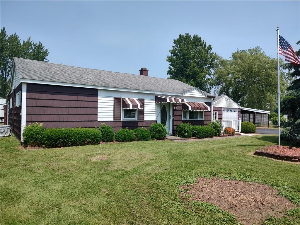 15 Douglas Dr, Waterloo, NY 13165 - view of front of house with a front yard, a carport, a chimney, and roof with shingles