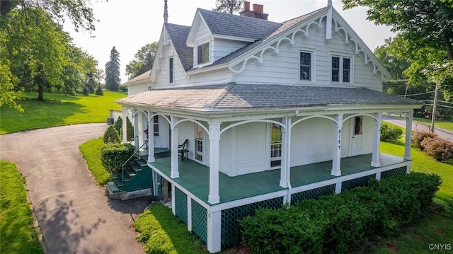 810 Franklin St, Skaneateles, NY 13152 - view of property exterior with a porch, a chimney, a yard, and a shingled roof
