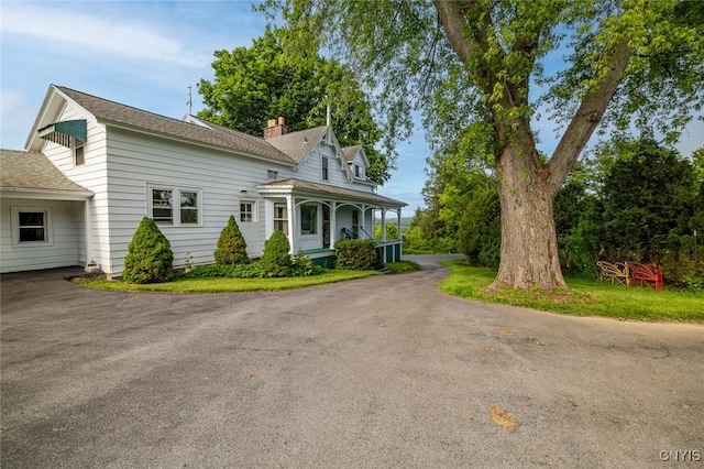 810 Franklin St, Skaneateles, NY 13152 - view of front of house featuring a porch, a chimney, driveway, and a shingled roof