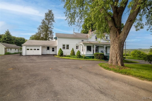 810 Franklin St, Skaneateles, NY 13152 - view of front facade featuring an attached garage, asphalt driveway, a porch, and a chimney