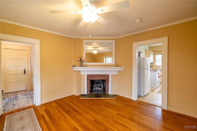 810 Franklin St, Skaneateles, NY 13152 - unfurnished living room with wood finished floors, ceiling fan, a brick fireplace, and ornamental molding