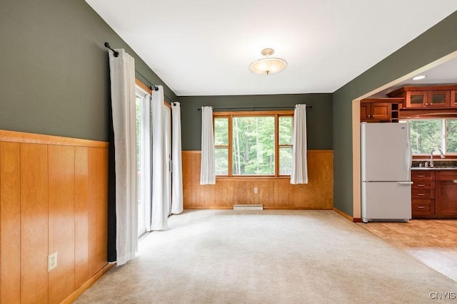 4581 Nelson Rd, Fenner, NY 13035 - unfurnished dining area with wainscoting, light colored carpet, and wood walls