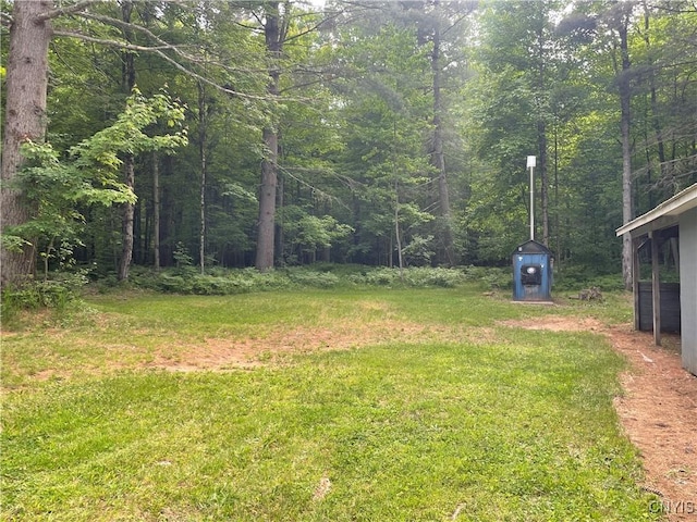 8054 Sand Pond Rd, Greig, NY 13343 - view of green lawn featuring a forest view and a shed