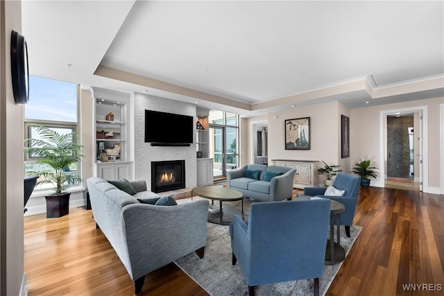 132 Lakefront Blvd Unit 804, Buffalo, NY 14202 - living area featuring a tray ceiling, a fireplace, plenty of natural light, ornamental molding, and wood finished floors