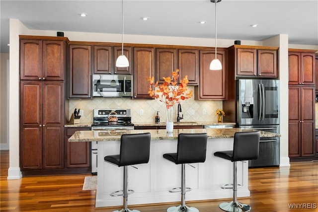 132 Lakefront Blvd Unit 804, Buffalo, NY 14202 - kitchen featuring stainless steel appliances, a breakfast bar area, wood finished floors, a center island with sink, and recessed lighting