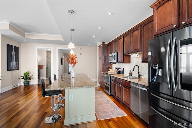 132 Lakefront Blvd Unit 804, Buffalo, NY 14202 - kitchen with appliances with stainless steel finishes, a center island, backsplash, wood finished floors, and a breakfast bar area