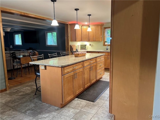 60 Cambridge Rd, Whitestown, NY 13492 - kitchen featuring a breakfast bar area, pendant lighting, light stone countertops, a center island, and brown cabinets