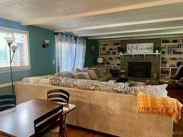 60 Cambridge Rd, Whitestown, NY 13492 - living area featuring beamed ceiling, dark wood finished floors, a fireplace with raised hearth, a textured ceiling, and built in features