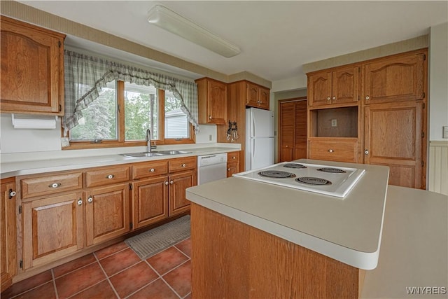 4724 Wilson Burt Rd, Wilson, NY 14172 - kitchen with white appliances, dark tile patterned floors, brown cabinetry, a center island, and light countertops