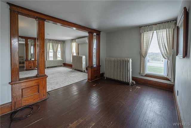 4724 Wilson Burt Rd, Wilson, NY 14172 - empty room with radiator heating unit, ornate columns, and dark wood-type flooring