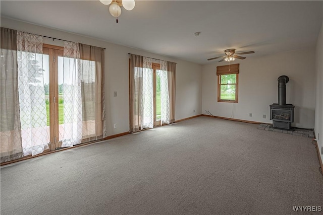 4724 Wilson Burt Rd, Wilson, NY 14172 - unfurnished living room with a ceiling fan, carpet, and a wood stove