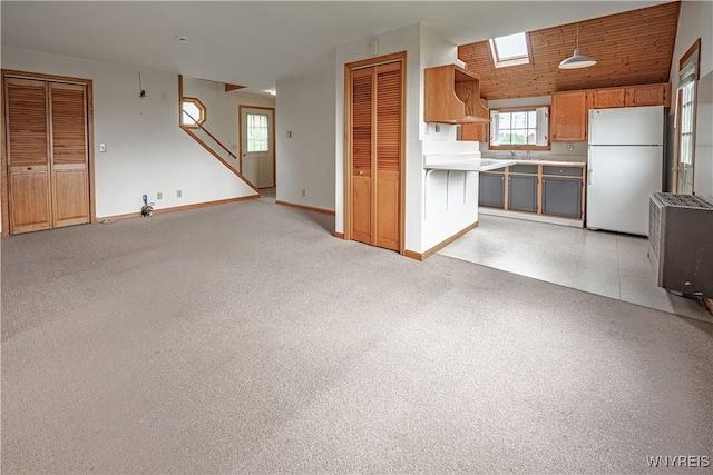 4724 Wilson Burt Rd, Wilson, NY 14172 - kitchen with freestanding refrigerator, open floor plan, light countertops, and brown cabinets