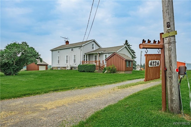 4724 Wilson Burt Rd, Wilson, NY 14172 - view of front facade with dirt driveway, a front lawn, a garage, and an outdoor structure