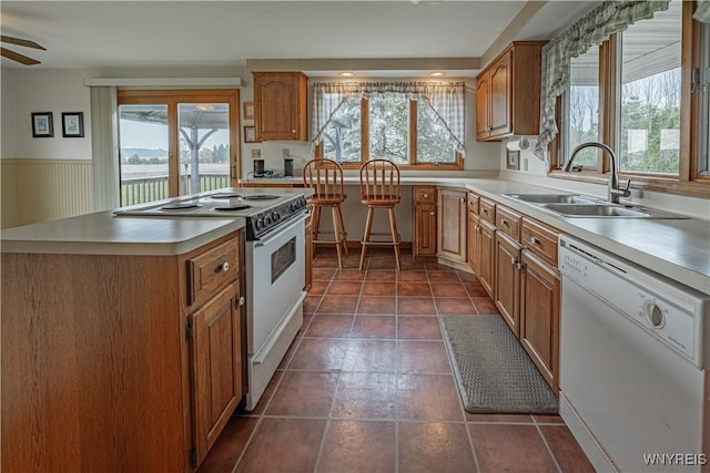 4724 Wilson Burt Rd, Wilson, NY 14172 - kitchen with white appliances, light countertops, a ceiling fan, brown cabinets, and wainscoting