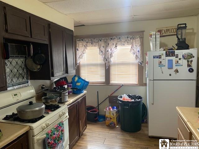400 Buffalo St, Jamestown, NY 14701 - kitchen with white appliances, light wood finished floors, light countertops, and dark brown cabinetry