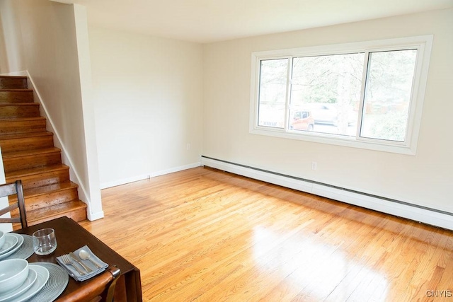 4114 Wetzel Rd, Clay, NY 13090 - unfurnished living room with a baseboard heating unit, wood finished floors, and stairway