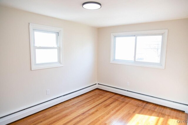 4114 Wetzel Rd, Clay, NY 13090 - empty room with a baseboard heating unit and light wood-style floors