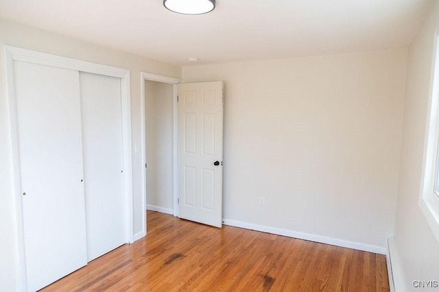 4114 Wetzel Rd, Clay, NY 13090 - unfurnished bedroom with a closet, light wood-style flooring, and baseboard heating