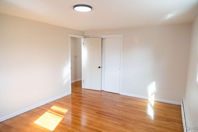 4114 Wetzel Rd, Clay, NY 13090 - unfurnished bedroom with baseboard heating, light wood finished floors, and a closet