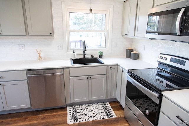 4114 Wetzel Rd, Clay, NY 13090 - kitchen featuring appliances with stainless steel finishes, backsplash, dark wood-style flooring, light countertops, and gray cabinets