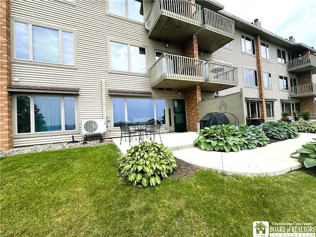 23 Seneca Dr, Chautauqua, NY 14728 - back of house featuring a lawn, brick siding, and a patio area