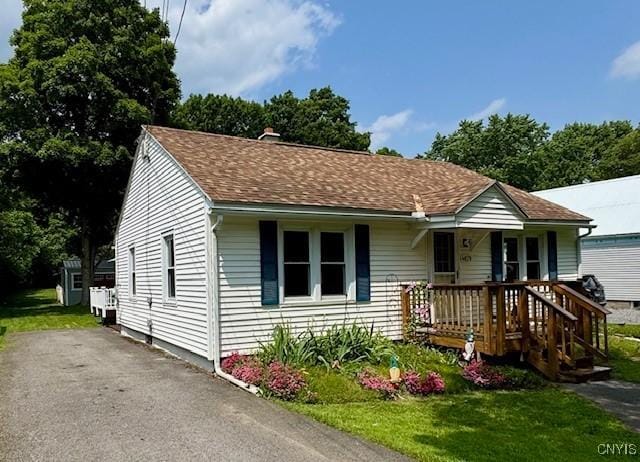 4079 Onondaga Blvd, Onondaga, NY 13031 - view of front facade with covered porch, a chimney, a front lawn, and a shingled roof