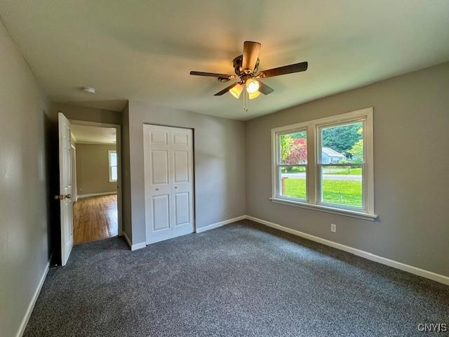 4079 Onondaga Blvd, Onondaga, NY 13031 - unfurnished bedroom featuring dark carpet, a closet, and ceiling fan