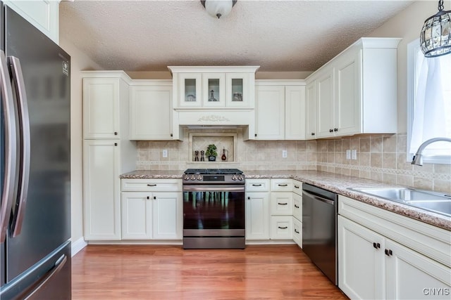 40 Phyllis Ln, Hastings, NY 13076 - kitchen with stainless steel appliances, a textured ceiling, white cabinets, decorative backsplash, and light wood finished floors