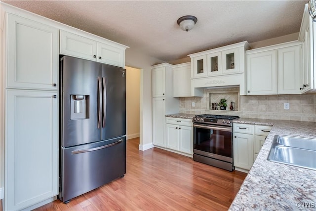 40 Phyllis Ln, Hastings, NY 13076 - kitchen with stainless steel appliances, tasteful backsplash, white cabinets, light wood-style flooring, and a textured ceiling